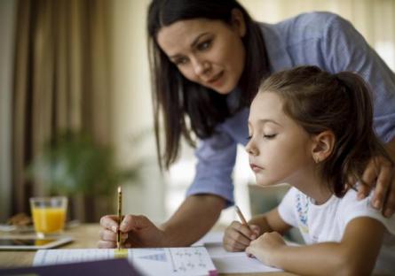 A mother helping her daughter with homework.