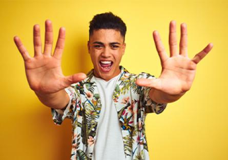 student wearing tshirt and aloha shirt holding up hands with 10 fingers