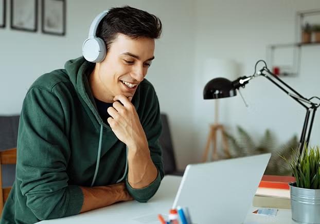 Student wearing a headset looking at a laptop screen.