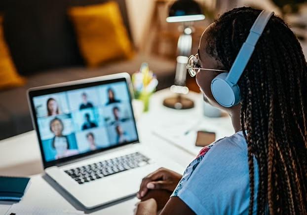 student wearing headphones participating in a virtual meeting.