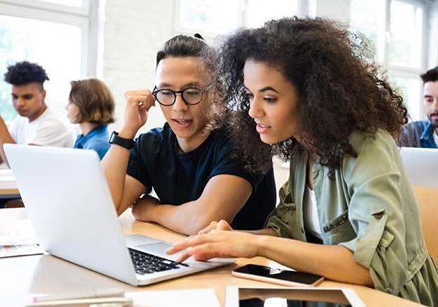 two students looking at a laptop screen