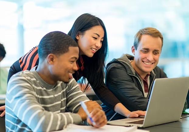 three students looking at a laptop
